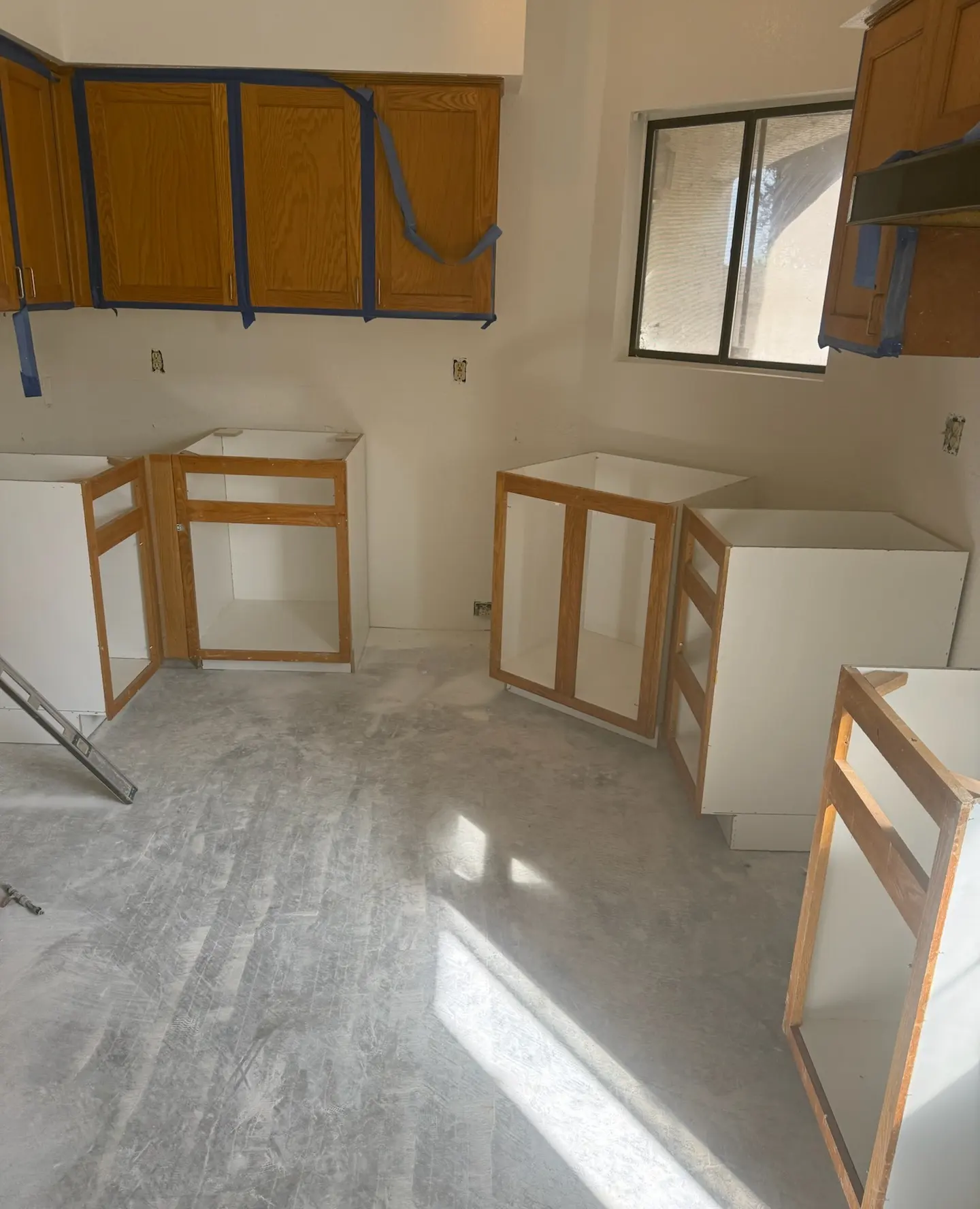 New base cabinets being set in a kitchen