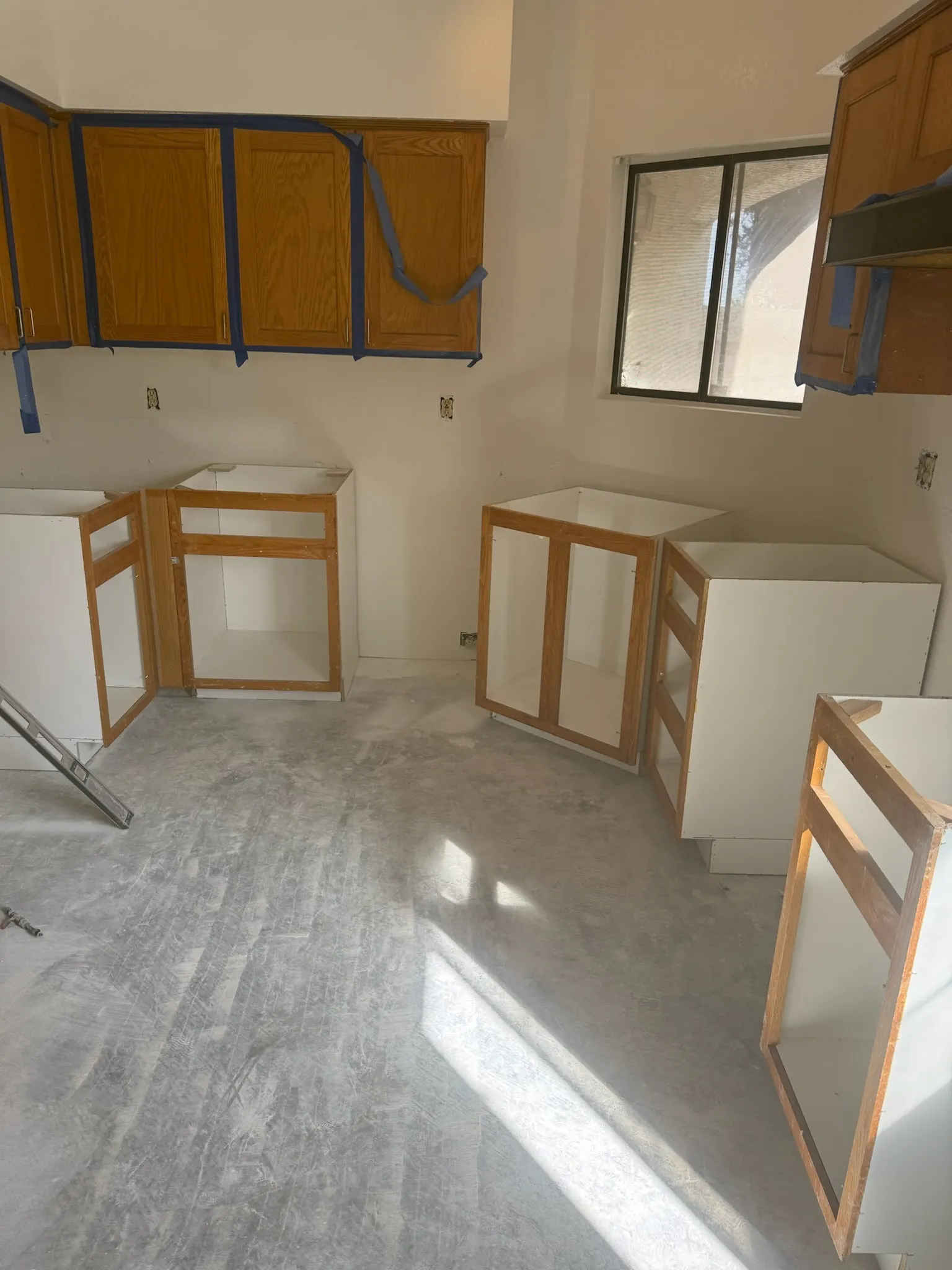 New base cabinets being set in a kitchen