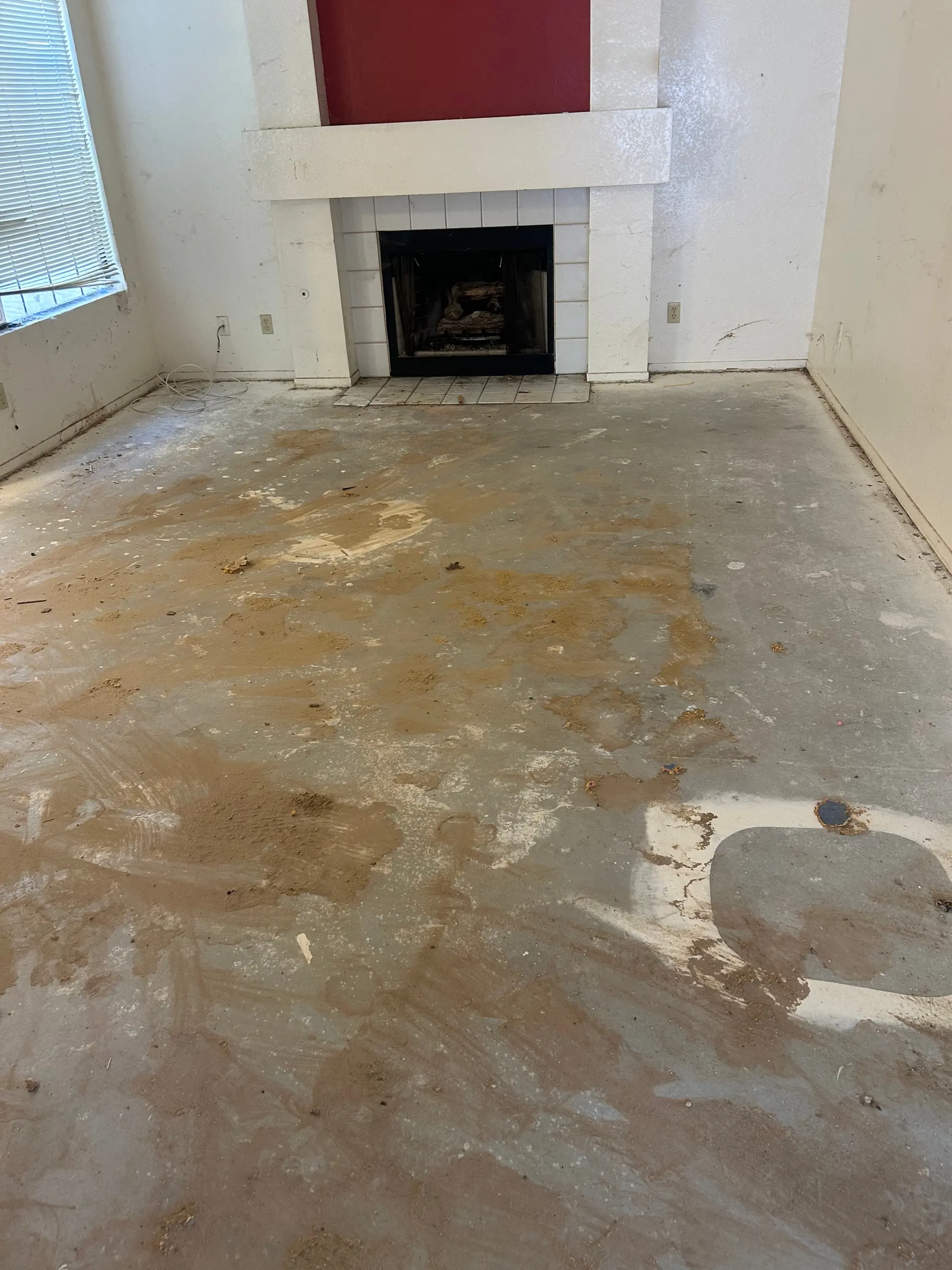 A living room before the work, with a stained bare floor