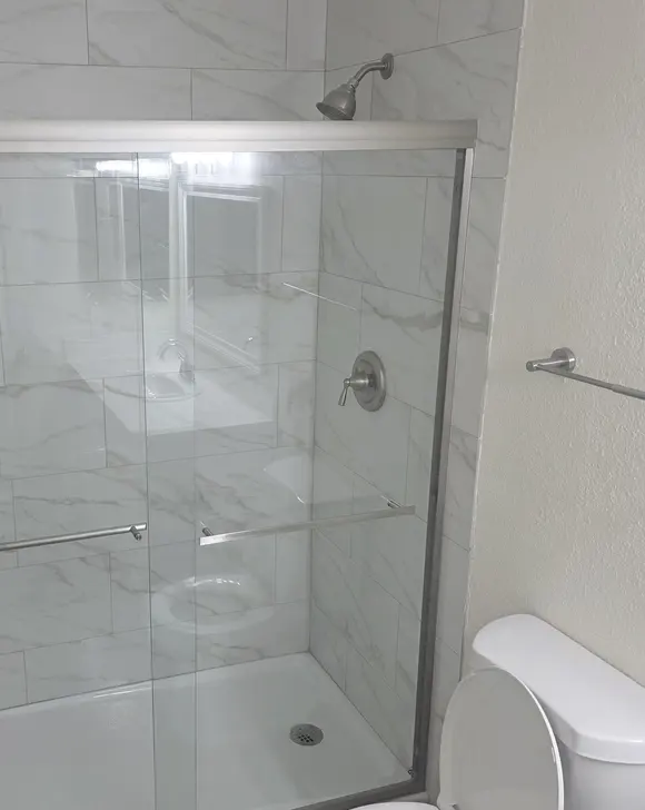 A tiled shower with a sliding glass door