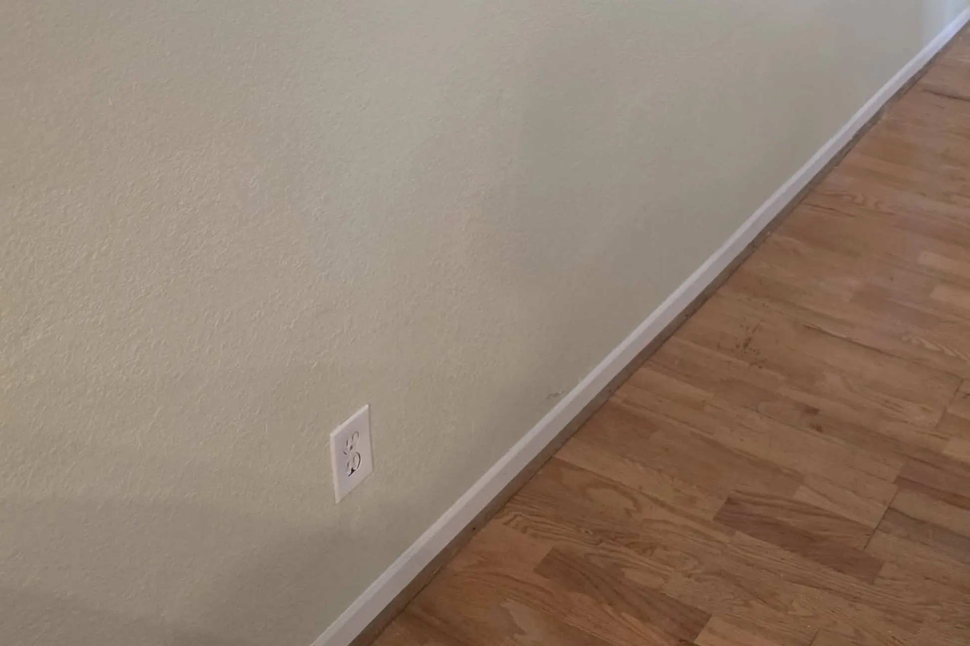 A patched and painted wall beside a new floor