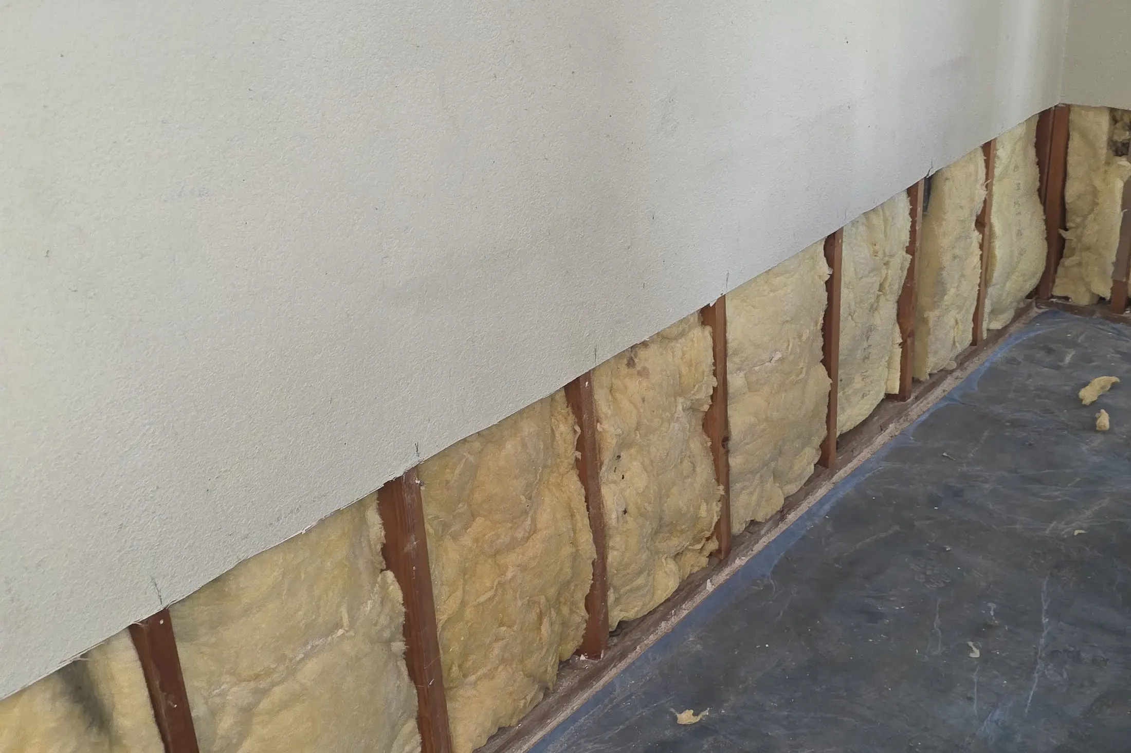 A wall cut open above the floor, with insulation showing